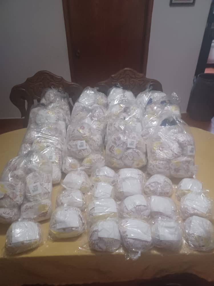 Mujer recibiendo su bolsa de panes en la entrega de Los Próceres